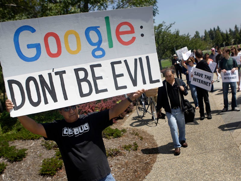 David Ledesma (left) of San Jose holds a sign as he walks with others who gathered to protest Google...