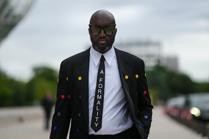 Virgil Abloh wears a white shirt, a black tie with 'A Formality' slogan, a black blazer jacket with ...
