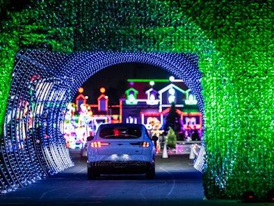 A car drives through a tunnel of lights as it enters the North Pole Village at the Night of Lights O...