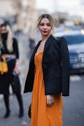 Madelyn Cline, who reignited dating rumors with Ross Butler, wears orange dress and black blazer out...