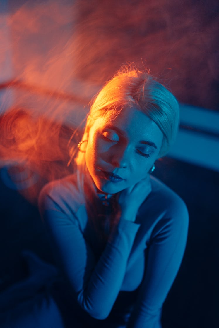 Woman standing in yellow and blue light, thinking about the spiritual meaning of the December 2021 n...