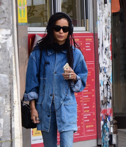 Zoe Kravitz wearing over-the-ear wired headphones and denim walking in Soho.