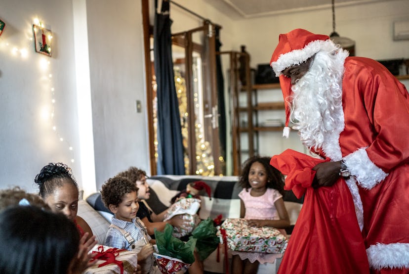 Santa Claus visiting kids and giving presents on Christmas at home