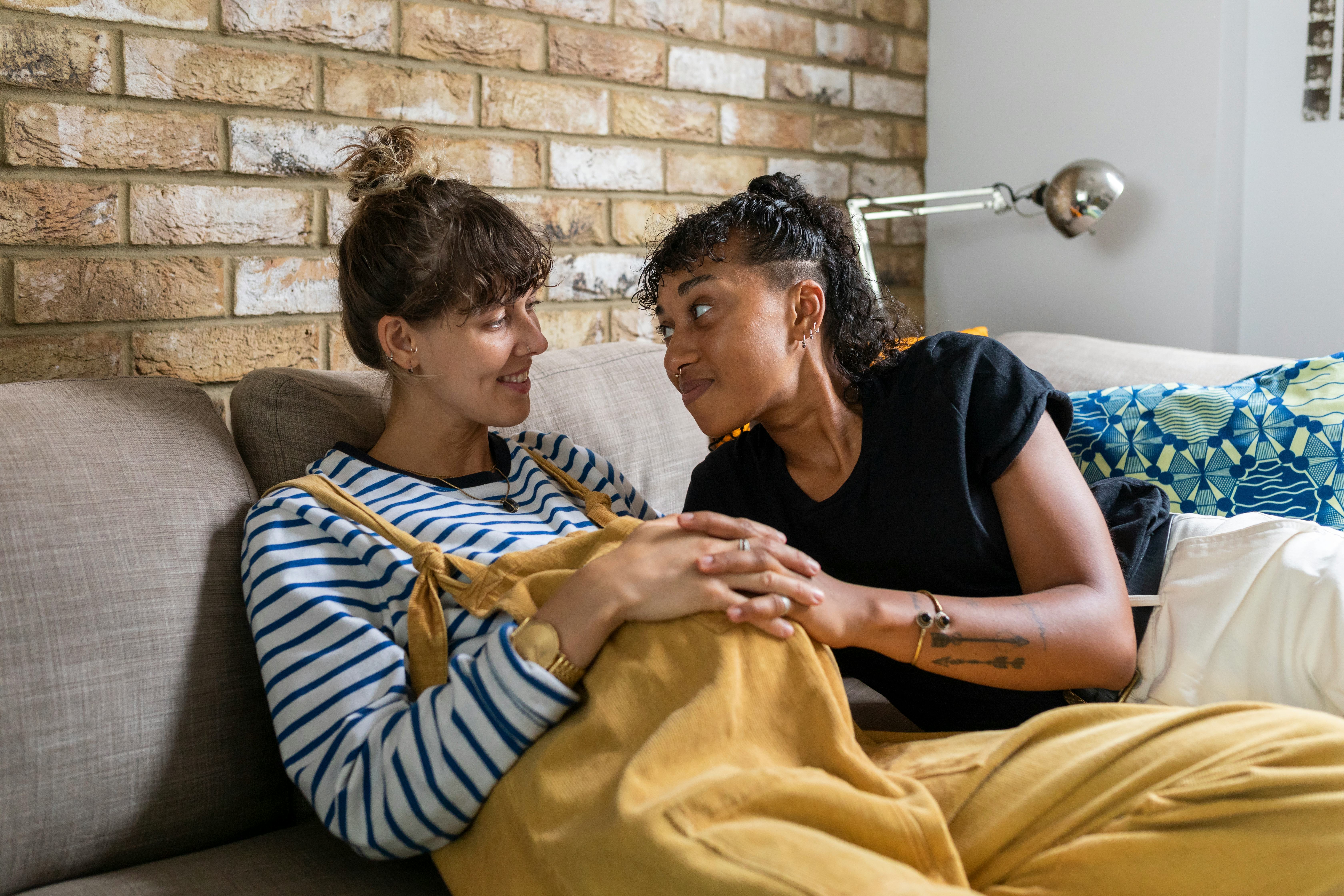 same-sex couple expecting baby lovingly looking at each other