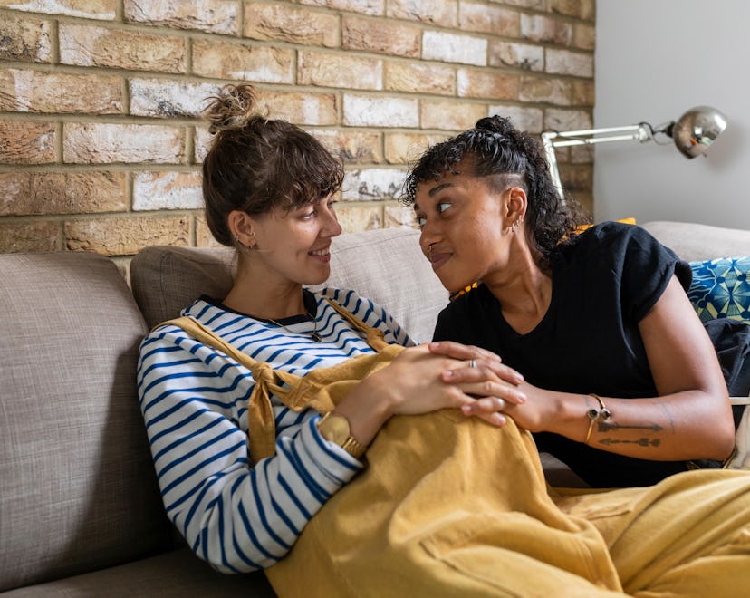 same-sex couple expecting baby lovingly looking at each other