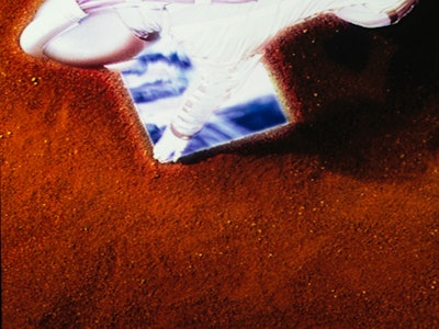 Astronaut shot from above with reflective surface on red dirt Mars environment