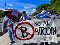 SAN SALVADOR, EL SALVADOR - OCTOBER 17: A demonstrator holds a sign against the approved Bitcoin law...
