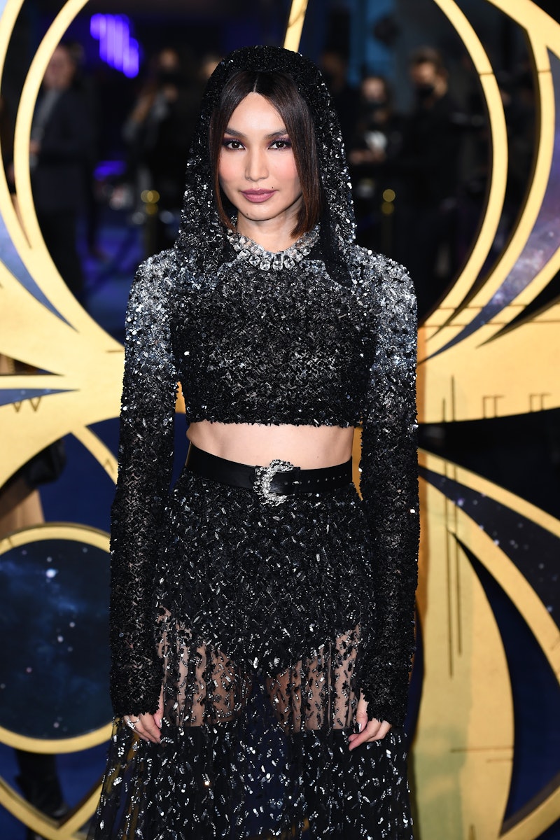 'Eternals' star Gemma Chan posing in a black and silver glittery gown with a cutout and belt on a re...