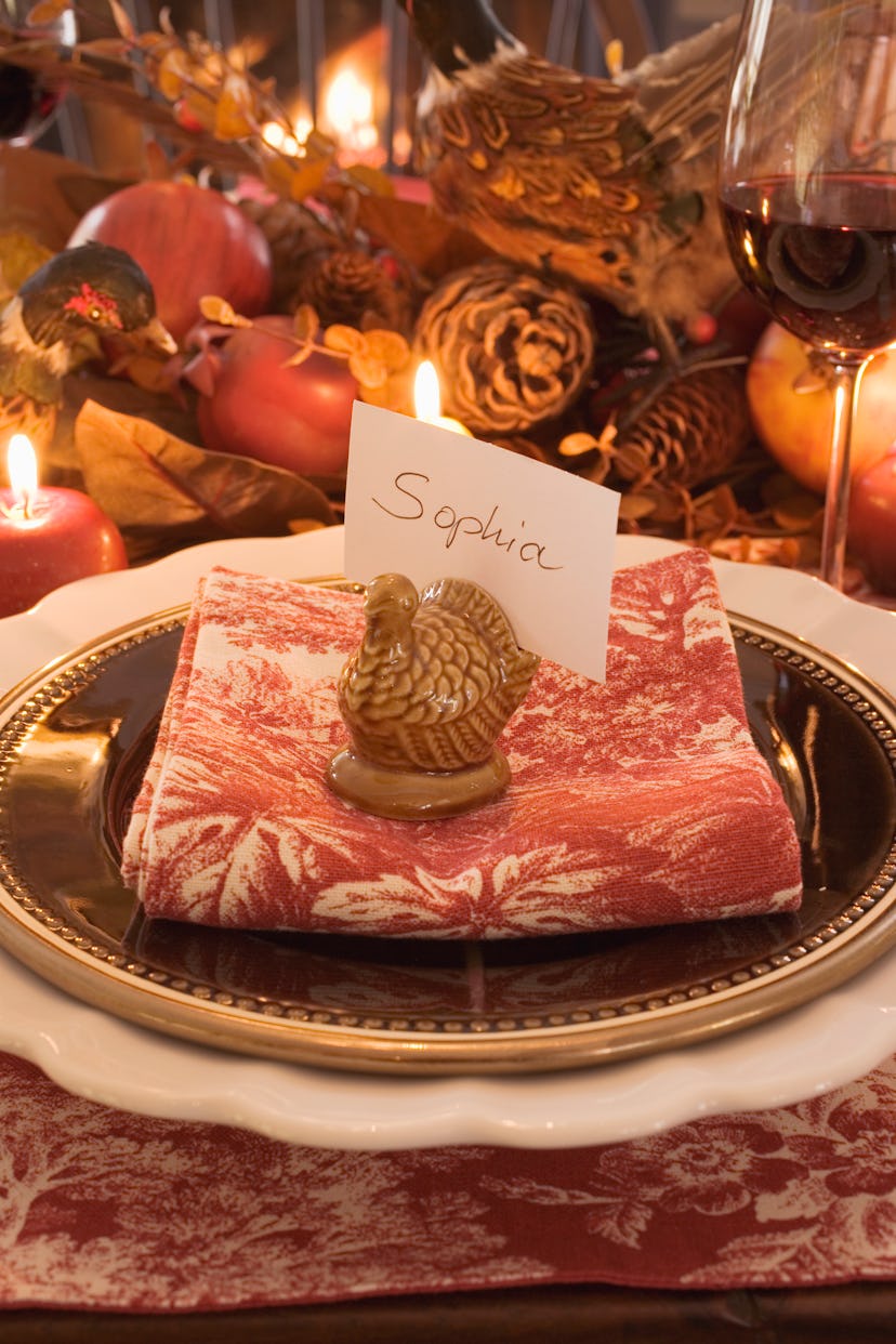 Image of a formal table set with a place card, which is tucked into a turkey place-card holder.