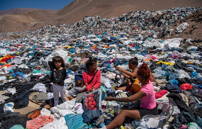 Women search for used clothes amid tons discarded in the Atacama desert, in Alto Hospicio, Iquique, ...