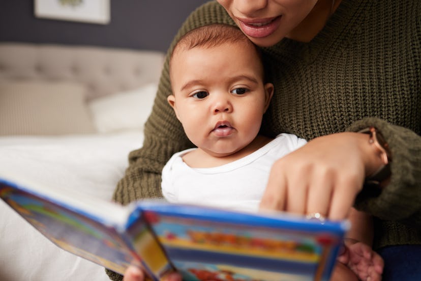 baby reading book with mom