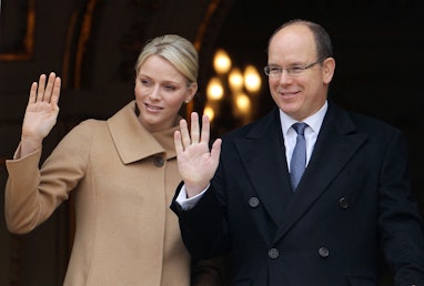 Prince Albert II of Monaco (R) and his wife, Princess Charlene, wave from a balcony during the Saint...