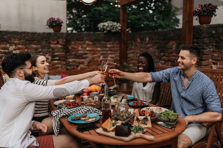 Group of friends having Friendsgiving dinner outside, for which they'll need some Friendsgiving puns...