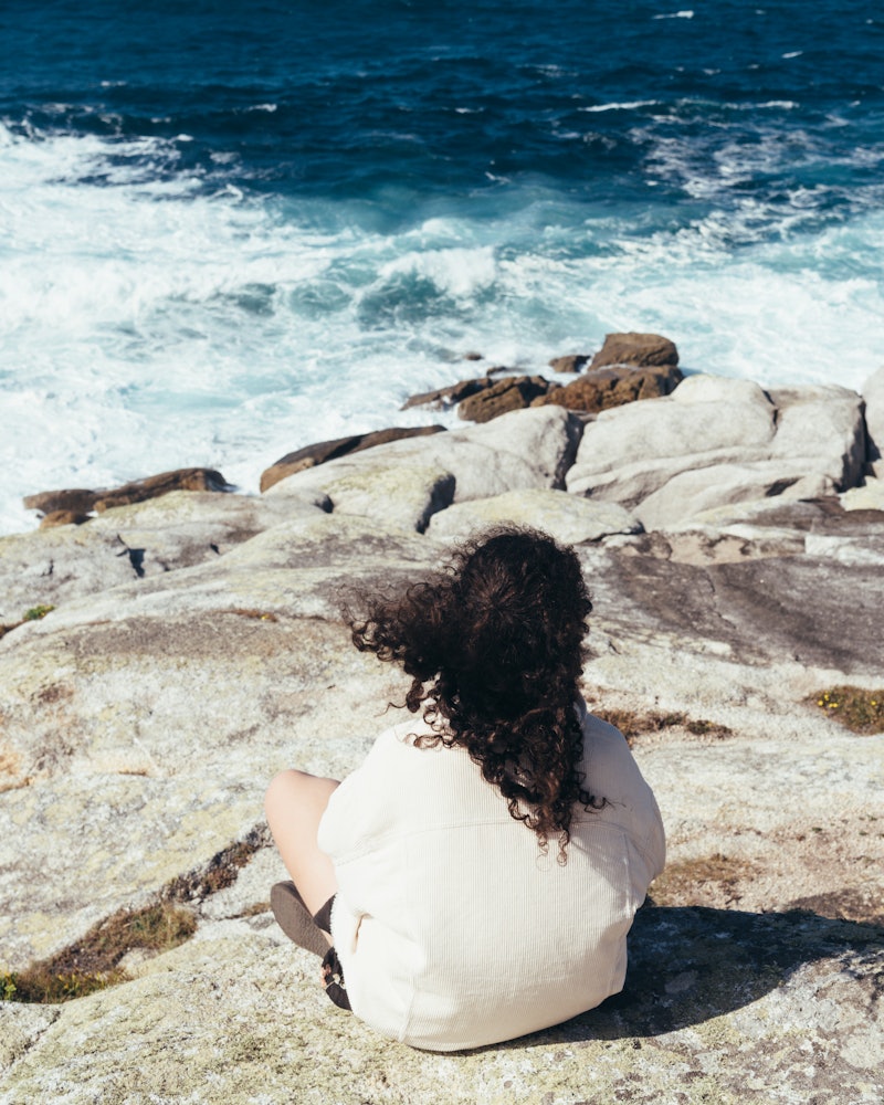 A woman looks out at the ocean. Here's your horoscope for November 10, 2021.