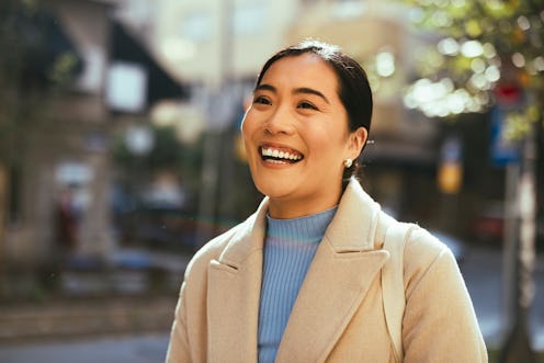 Beautiful smiling Asian businesswoman enjoy walking at city street.