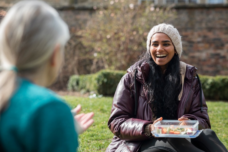 An over-the-shoulder shot of women who have been working together on a community garden outreach pro...