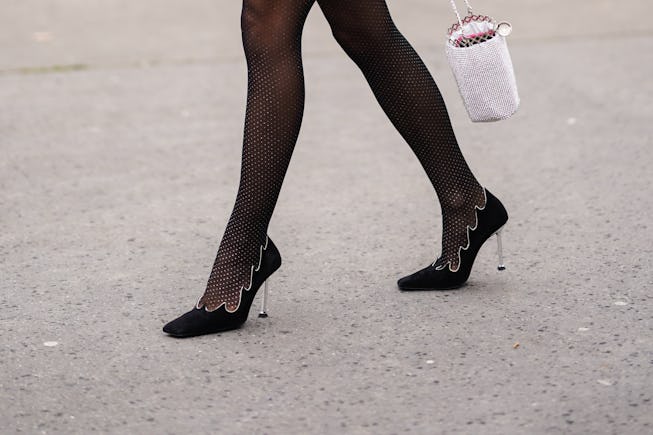 PARIS, FRANCE - FEBRUARY 28: A guest wears tights with polka dots, black pointy shoes with metallic ...