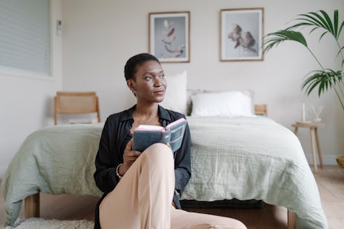 Woman enjoying read a book while relaxing at home. Hobbies and literature concept.