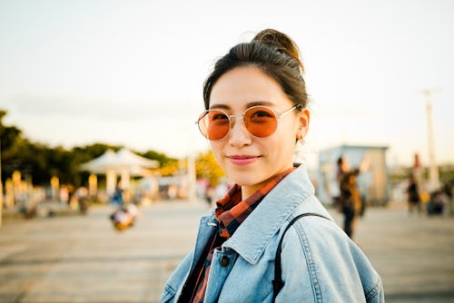 A woman with rose-colored glasses looks at the camera. A numerologist explains life path 8's meaning...