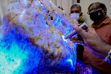 People inspect the single natural corundum (blue sapphire) named 'Queen of Asia', considered the lar...