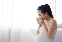 pregnant woman blowing nose