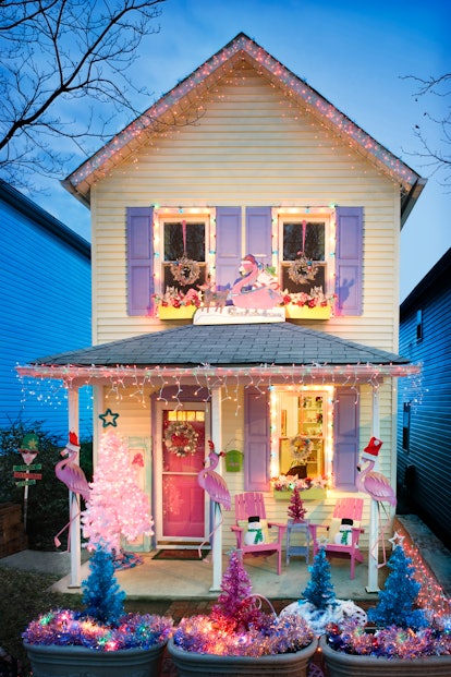 a house decorated in pinks blues and purples for christmas, with flamingos