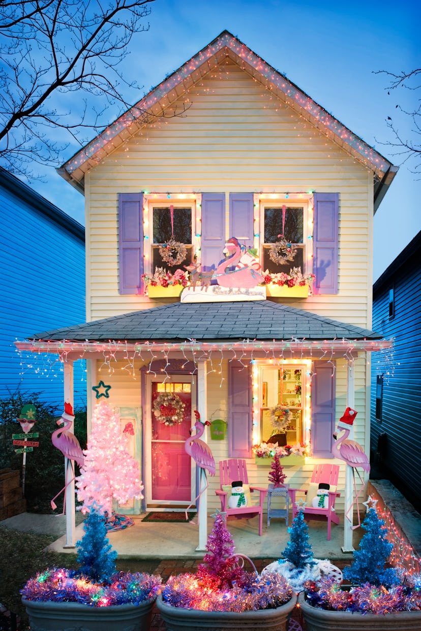 a house decorated in pinks blues and purples for christmas, with flamingos