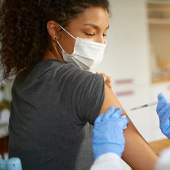 Young woman wearing mask getting vaccinated
