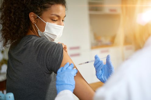 Young woman wearing mask getting vaccinated