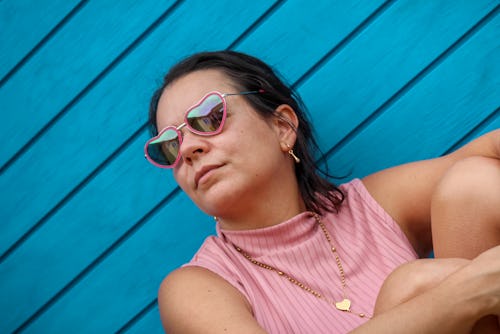 A woman looks over her shoulder wearing heart-shaped glasses. Here's how venus retrograde 2021 will ...