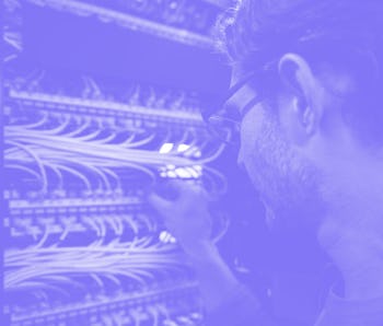 Computer engineer fixing an outage in the server room at the office - technology concepts