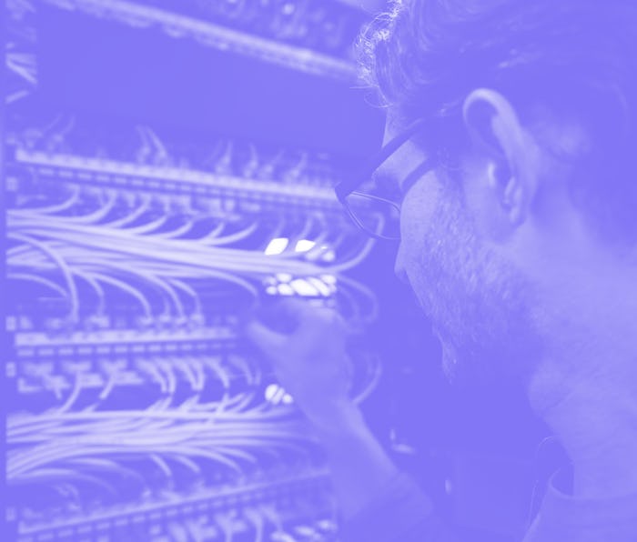 Computer engineer fixing an outage in the server room at the office - technology concepts