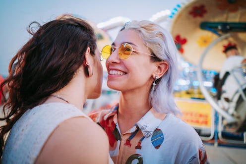 Happy young couple on carousel in amusement park