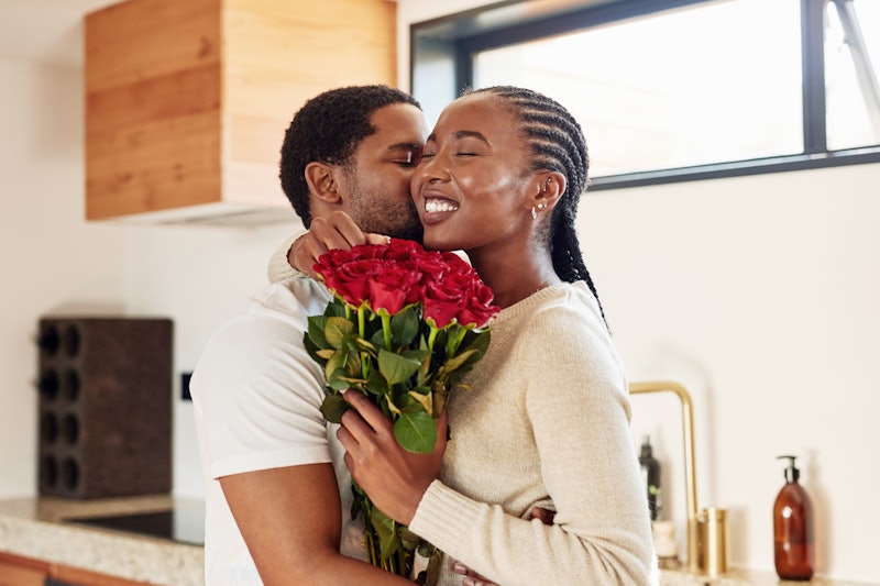 Woman receiving a bouquet of roses from her partner 