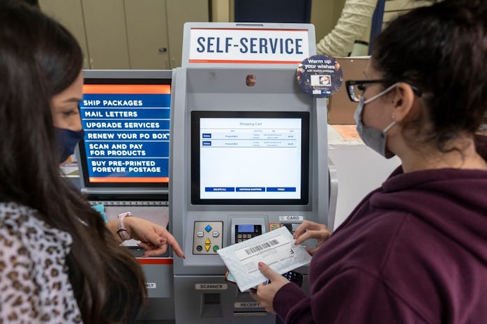 Van Nuys, CA - November 30: USPS Retail Support Specialist Ana Medina helps customer Jennifer Saldan...