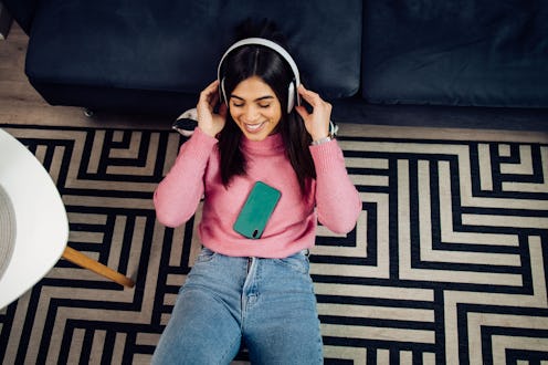 Portrait of a beautiful young woman listening to the music and enjoying at home.