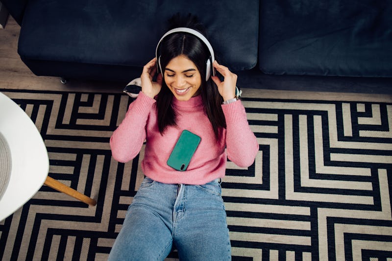 Portrait of a beautiful young woman listening to the music and enjoying at home.