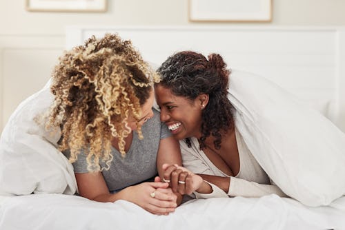 Two women snuggle in bed. Life path 4, 6, and 9 are compatible matches for life path 8.
