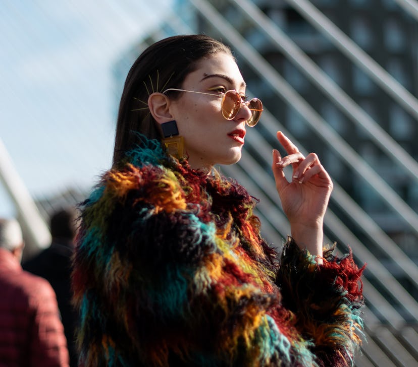 young woman posing in colorful coat as she reflects on Uranus retrograde 2022 ending on Jan. 18, 202...