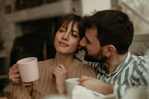Spontaneous and loving photo of a beautiful young woman, a brunette with bangs, looking away with a ...