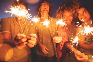 A group of friends play with sparklers as they celebrate New Year's Eve 2021 with Instagram captions...
