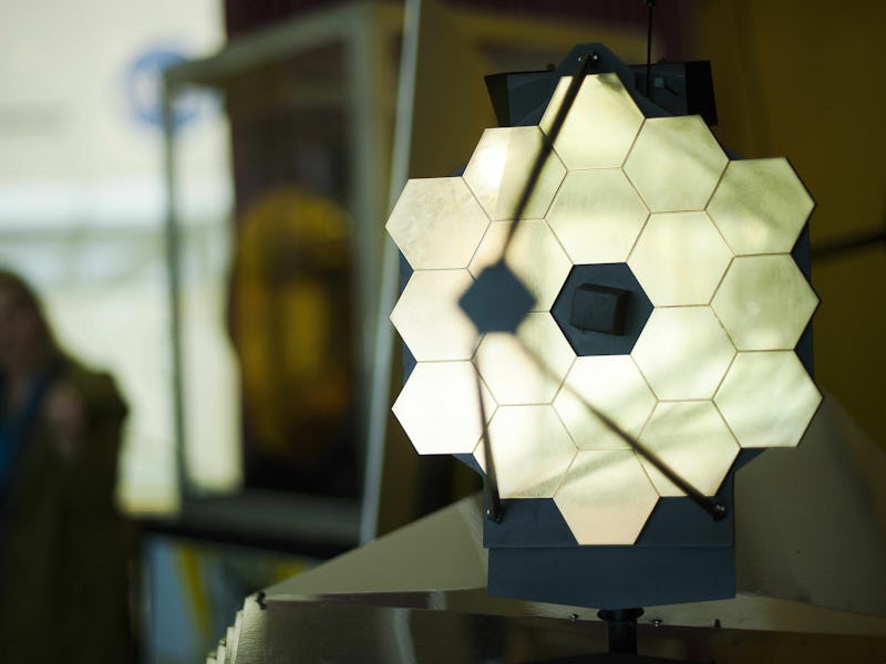 A woman stands near a model of the James Webb Space Telescope (JWST) at NASA Goddard Space Flight Ce...
