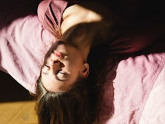 young woman hanging upside down with eyes closed reflects on the emotional meaning of the january 20...