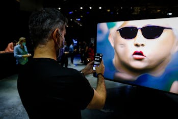 People interact with an NFT artwork by German artist Mario Klingeman during Art Basel 2021 at Miami ...