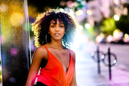 Beautiful young black woman outdoors at night time in a city