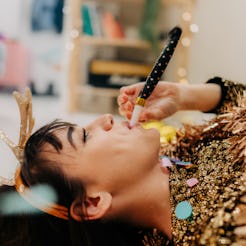 A woman blows a party horn. These are the luckiest days in 2022 for your career, according to your z...