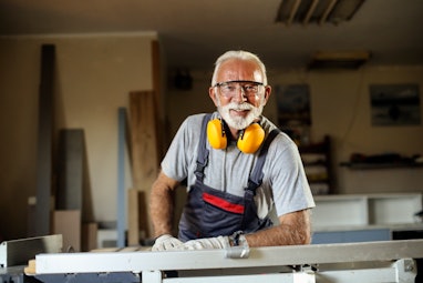 Senior man working as a carpenter in his workshop. About 65 years old, Caucasian male.