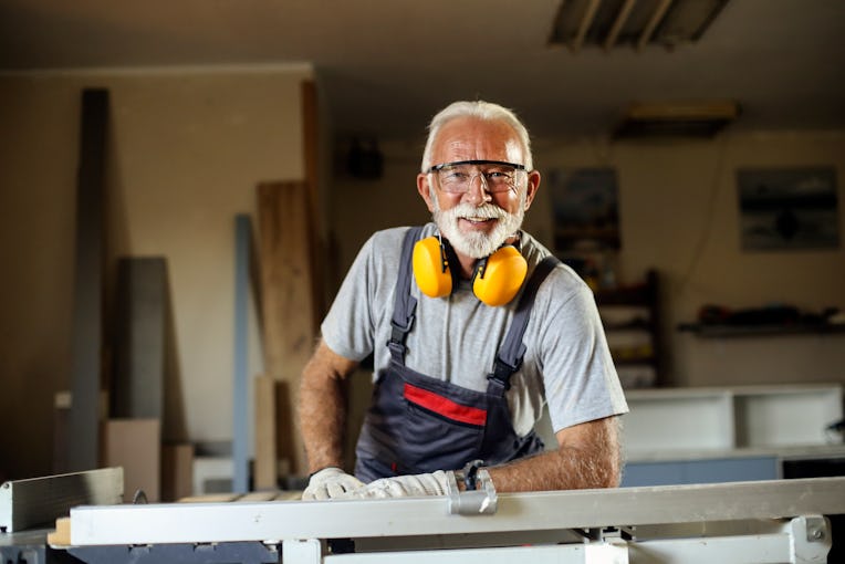 Senior man working as a carpenter in his workshop. About 65 years old, Caucasian male.