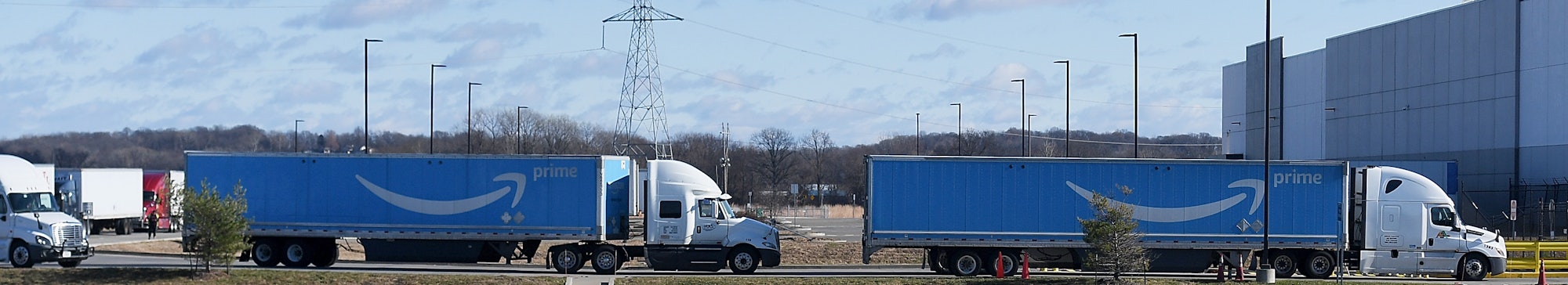 EDWARDSVILLE, IL - DECEMBER 11: Arriving Amazon shipment trucks are seen staged near the damaged Ama...
