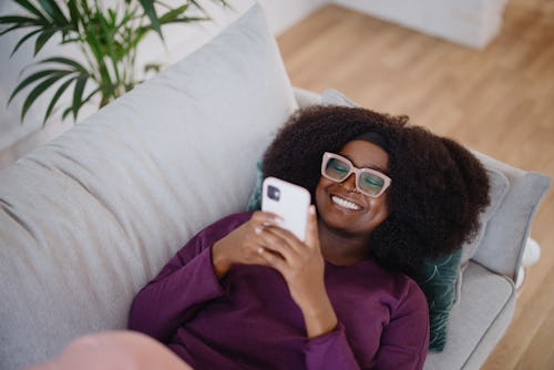 Young woman reads about how to use Hinge dating app on iPhone.